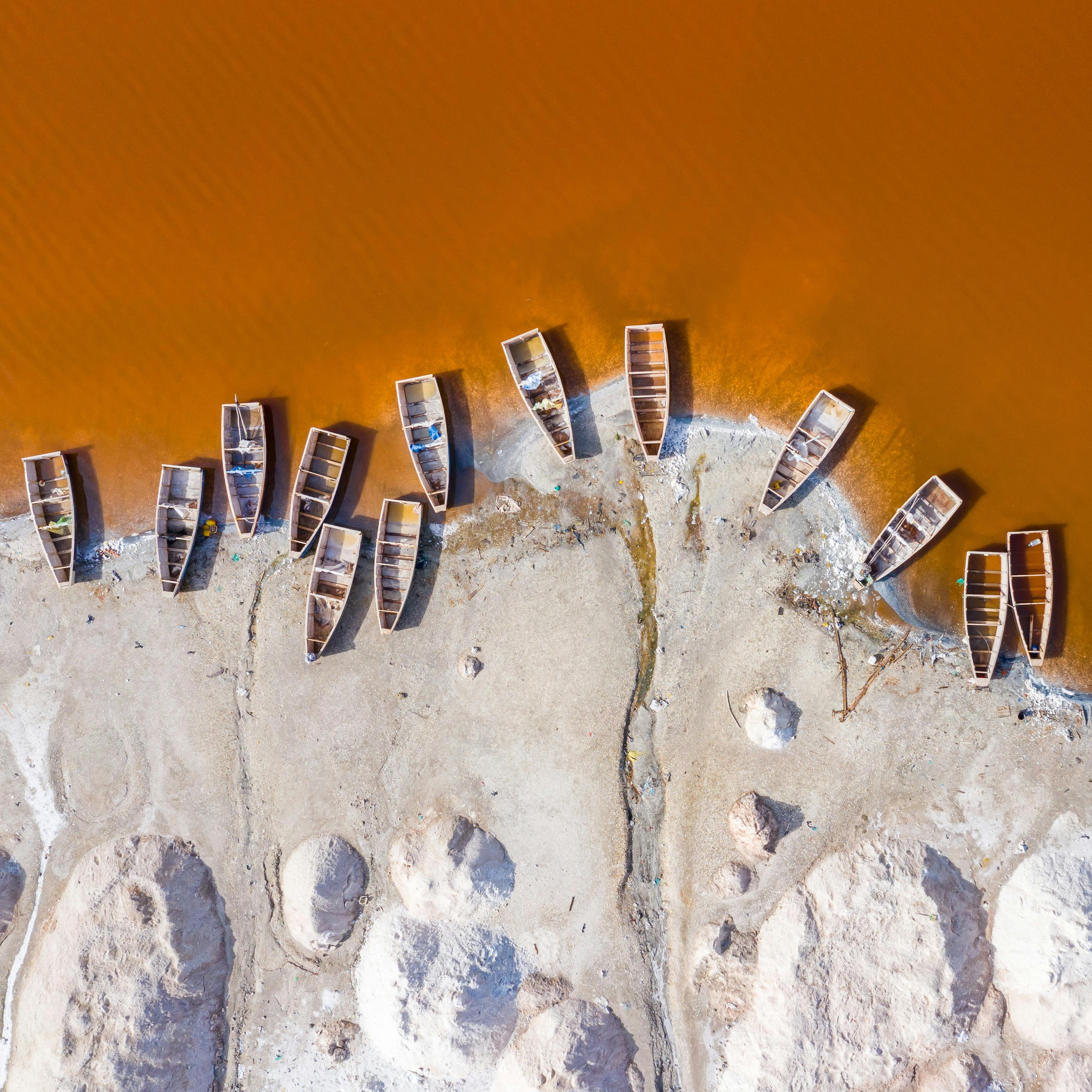 Aerial view of traditional wooden boats on golden African riverbank